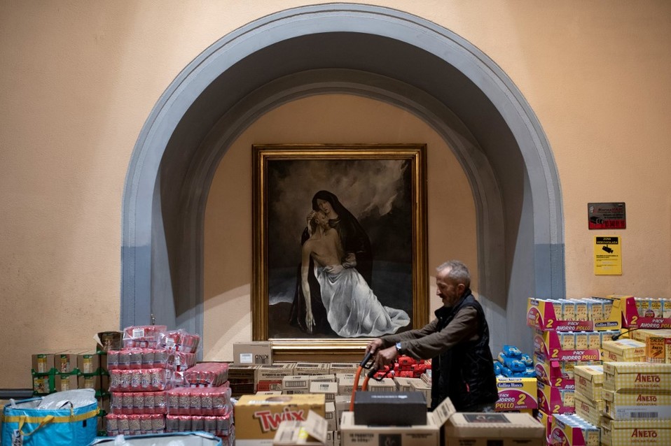 En Barcelona, un voluntario prepara raciones de comida para donar. (AFP)