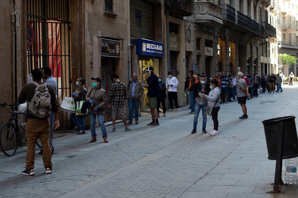 Personas aguardan para recibir apoyo alimenticio en Barcelona. (AFP)